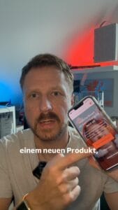 Mann zeigt neues WarsoWerk Produkt auf Smartphone.